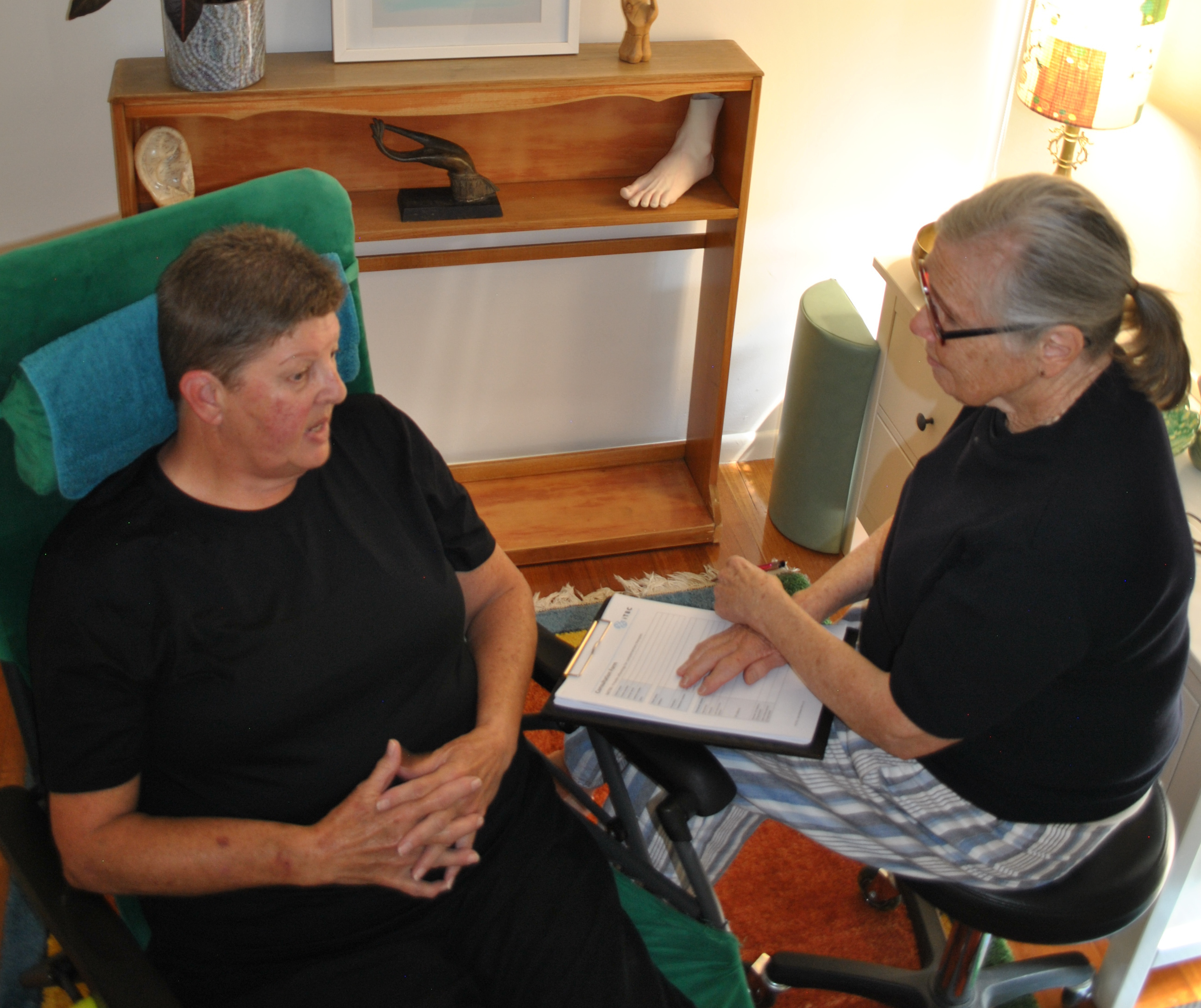 Nonie sitting down & discussing with a client